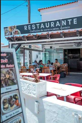 Esplanada do Restaurante & Pizzaria Catarina, com mesas na rua e o letreiro da casa